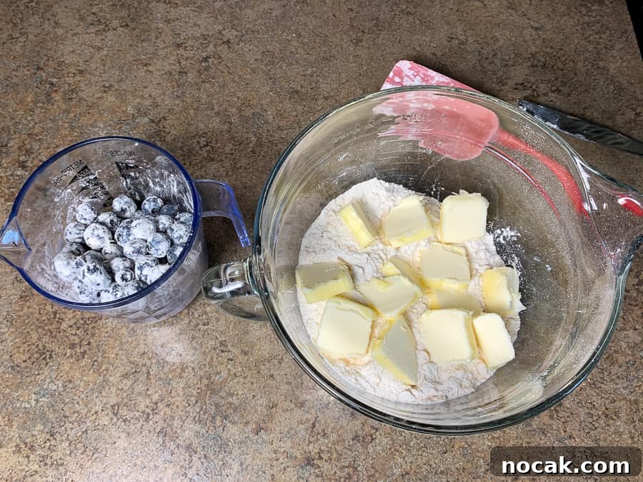 Blueberry Banana Oat Muffins for Quick Breakfast 6 Flour stirred into blueberries and pieces of butter on blueberry oatmeal muffin base mix