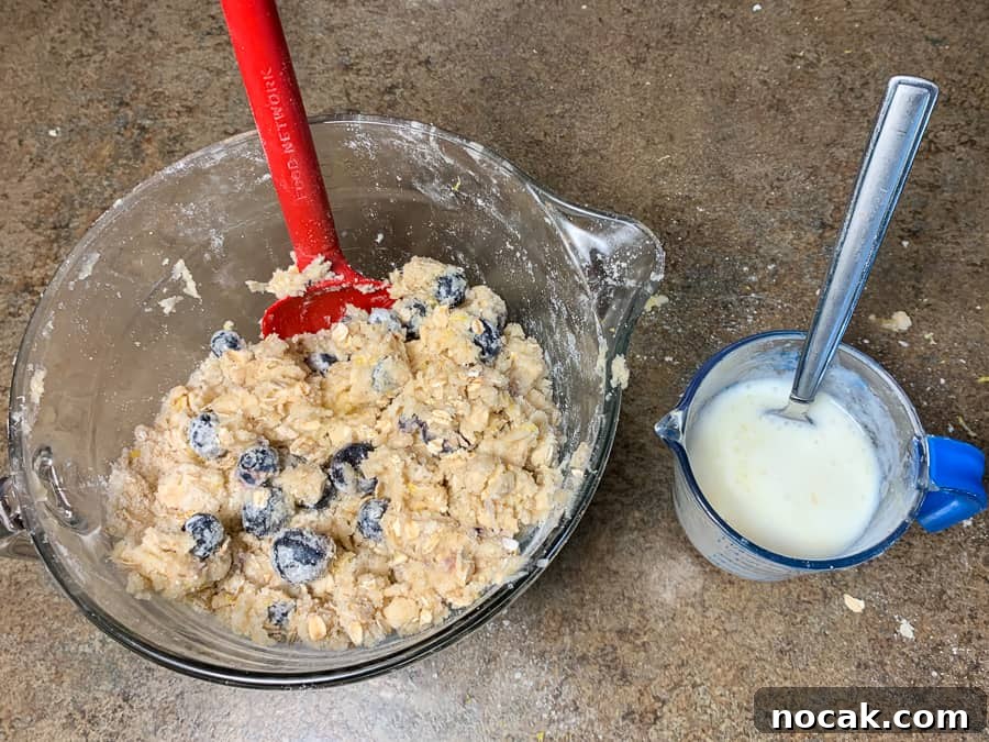 Blueberry Banana Oat Muffins for Quick Breakfast 7 Fruit, oatmeal and flour in mixing bowl with buttermilk and egg mixed together
