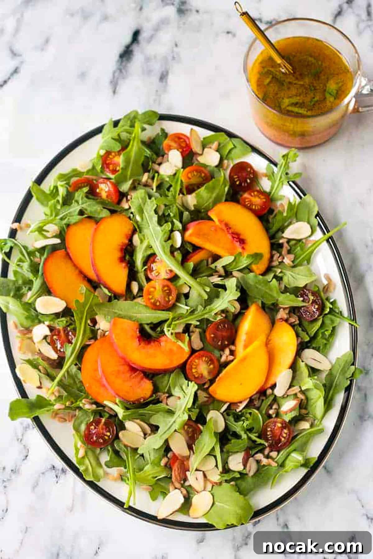 Arugula, Peach & Farro Salad with Orange Vinaigrette 2 Arugula salad with sliced peaches, grape tomatoes, slivered almonds, and farro.