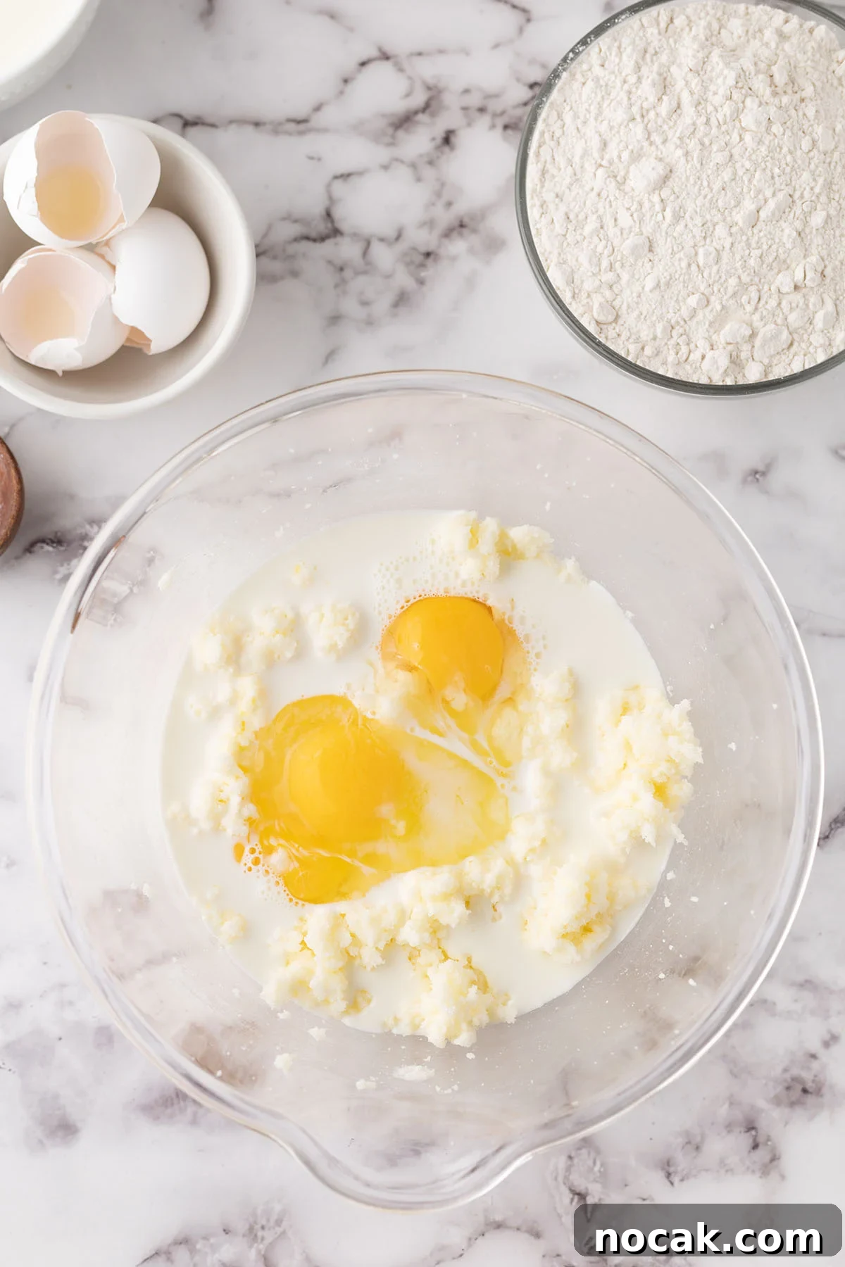 Creamy Banana Pudding Poke Cake Recipe for Dessert Fans 5 Eggs and heavy cream are added to the creamed butter and sugar in the mixing bowl.