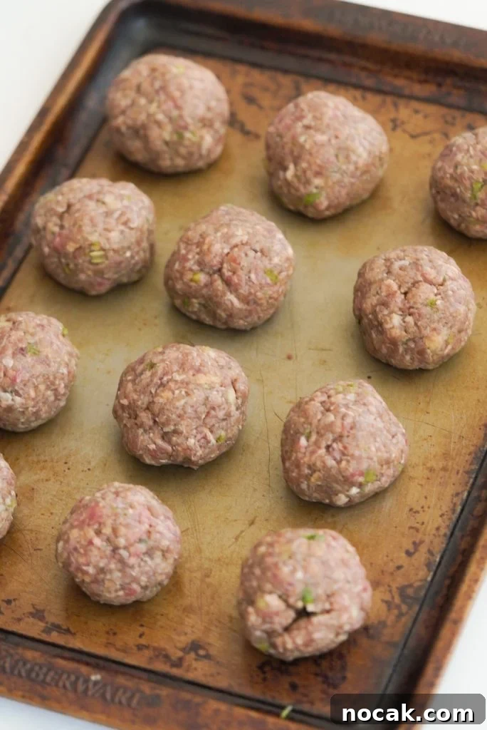 Spicy Firecracker Meatballs with Sweet Chili Glaze 8 12 raw meatballs rolled and placed on a baking sheet.
