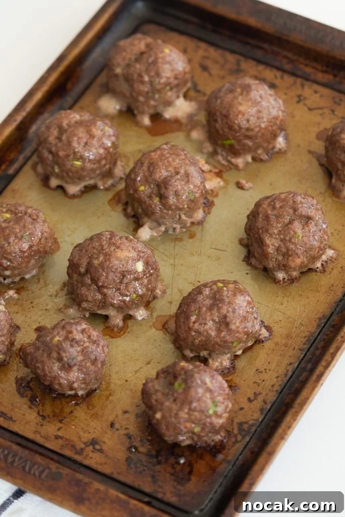 Spicy Firecracker Meatballs with Sweet Chili Glaze 9 process shot - firecracker meatballs on a baking sheet after baking.