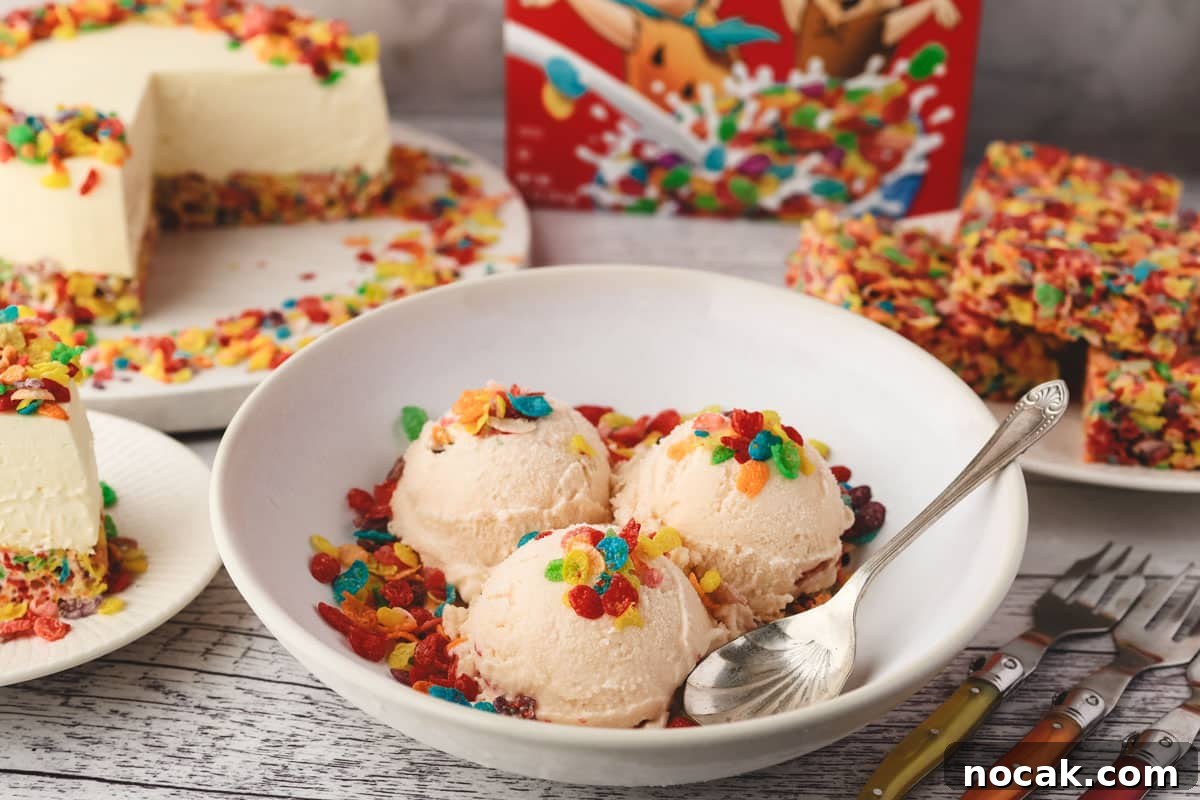 Fruity Pebbles Ice Cream Recipe: Nostalgic Cereal Ice Cream Treat 7 Three scoops of Fruity Pebbles ice cream decorated with Fruity Pebbles cereal, in a bowl with a spoon on the side and Fruity Pebbles cheesecake and Fruity Pebbles krispy treats in the background.