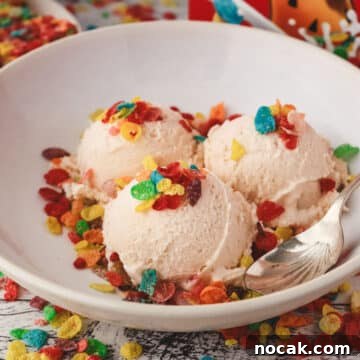 Fruity Pebbles Ice Cream Recipe: Nostalgic Cereal Ice Cream Treat 8 Three scoops of Fruity Pebbles ice cream decorated with Fruity Pebbles cereal, in a bowl with a spoon on the side.