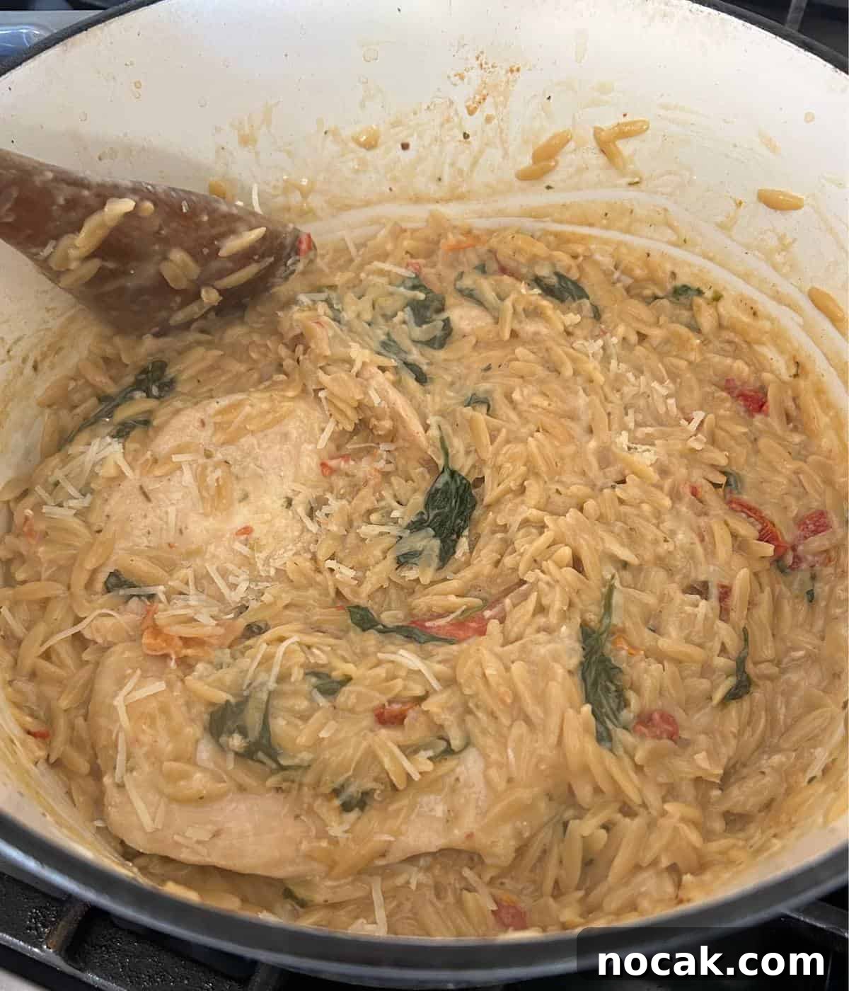 Creamy One-Pot Chicken and Orzo Bake: Comforting Weeknight Meal 11 Adding cheese to orzo in pot.