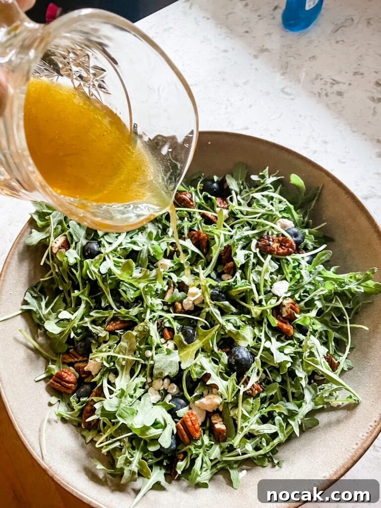 Summer Arugula Salad with Feta and Fresh Blueberries 2 The dressing being poured into the Summer Arugula, Feta, and Blueberry Salad