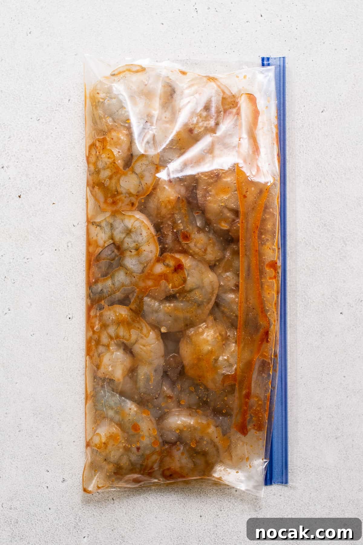 Kung pao shrimp is made with a sweet and spicy sauce, juicy shrimp, and bell peppers for a colorful, high-protein meal ready in 30 minutes. shrimp marinating in sauce.