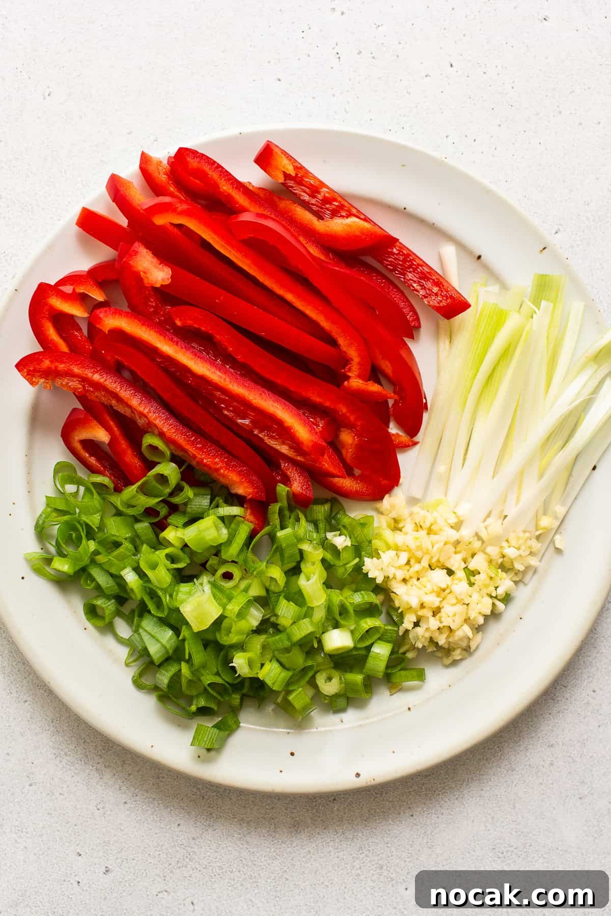 Kung pao shrimp is a 30-minute stir fry recipe that's sweet and spicy. We're serving ours with white rice and bell peppers. sliced veggies on platter.