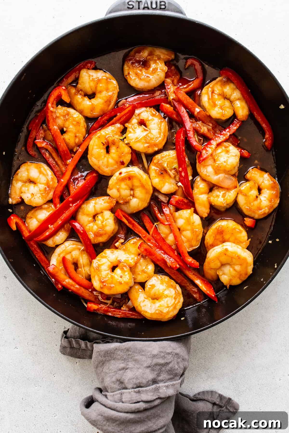Kung pao shrimp is a 30-minute stir fry recipe that's sweet and spicy. We're serving ours with white rice and bell peppers. kung pao shrimp in skillet.