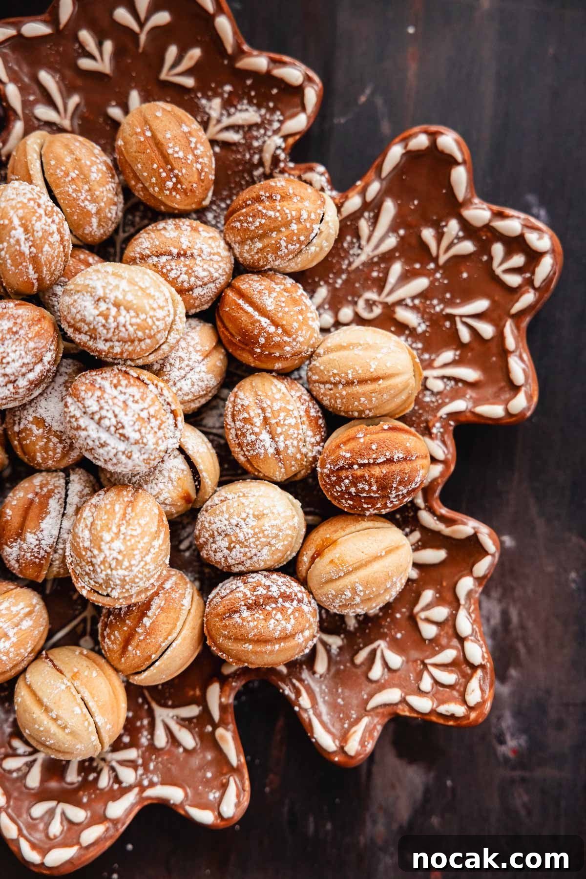 Oreshki Walnut Cookies Recipe — Russian Fillable Pastry Treats 14 walnut shaped cookies aka oreshki on a snowflake plate