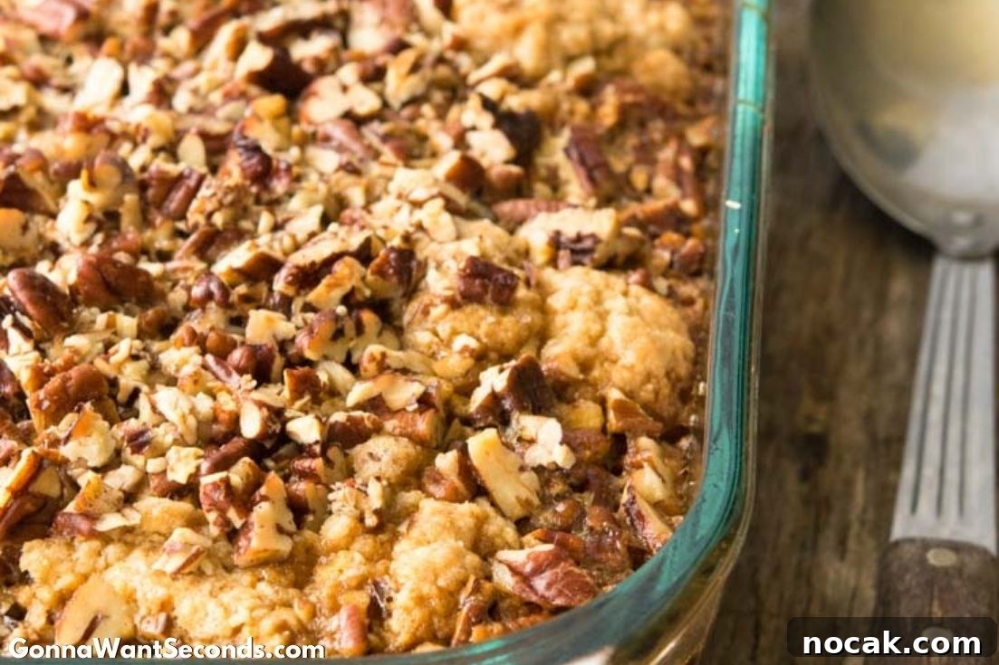 Pecan Pie Cobbler brings together the ooey gooey filling of pecan pie with the decadent cake-like topping of your favorite cobbler! It’s to die for delish! #Pecans #PecanPie #Cobbler #Dessert Pecan Pie Cobbler in a casserole dish