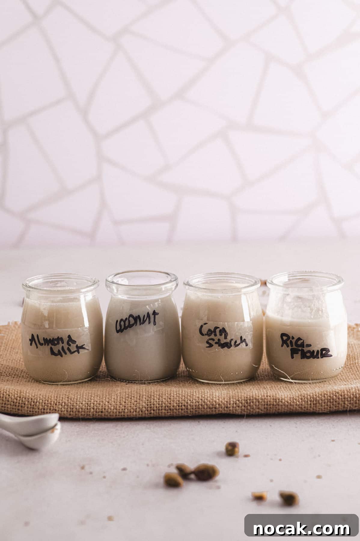 Malabi Rose Water Milk Pudding with Vegan Options 3 Four jars of malabi labeled with the different types of milk or thickeners used.