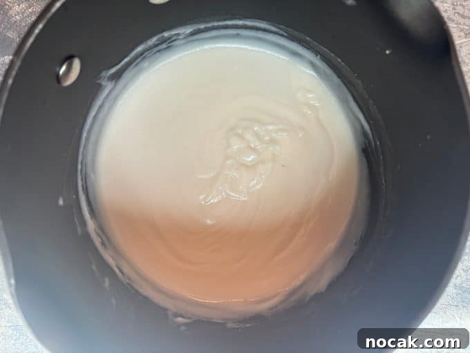 Malabi Rose Water Milk Pudding with Vegan Options 6 overhead image of a nonstick pot. Inside the pot is the thickening malabi pudding.