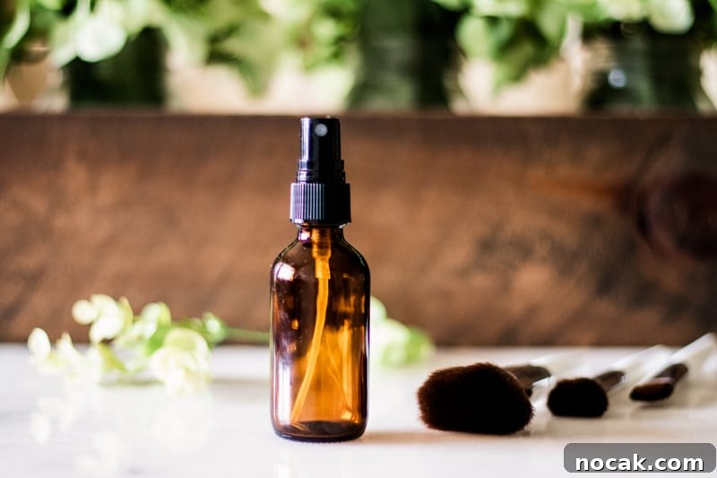 DIY Natural Makeup Recipes: Homemade Cosmetics for Glowing Skin 13 Homemade makeup setting spray for dry skin with flower pedals and wooden background.