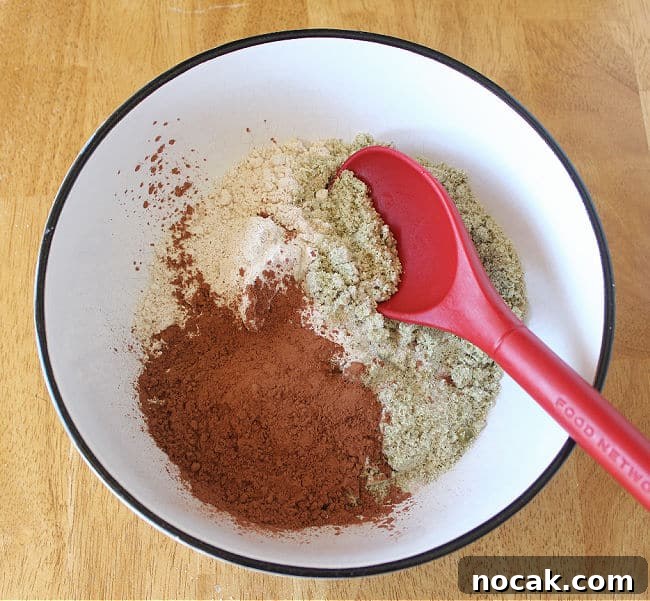 Fudgy Dark Chocolate Cookies — Nut Free Recipe 4 Flours and cocoa powder in a large white bowl.