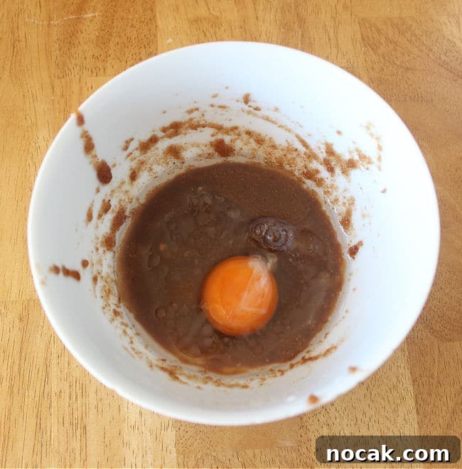 Fudgy Dark Chocolate Cookies — Nut Free Recipe 6 Egg, sugar, and oil in a white bowl.