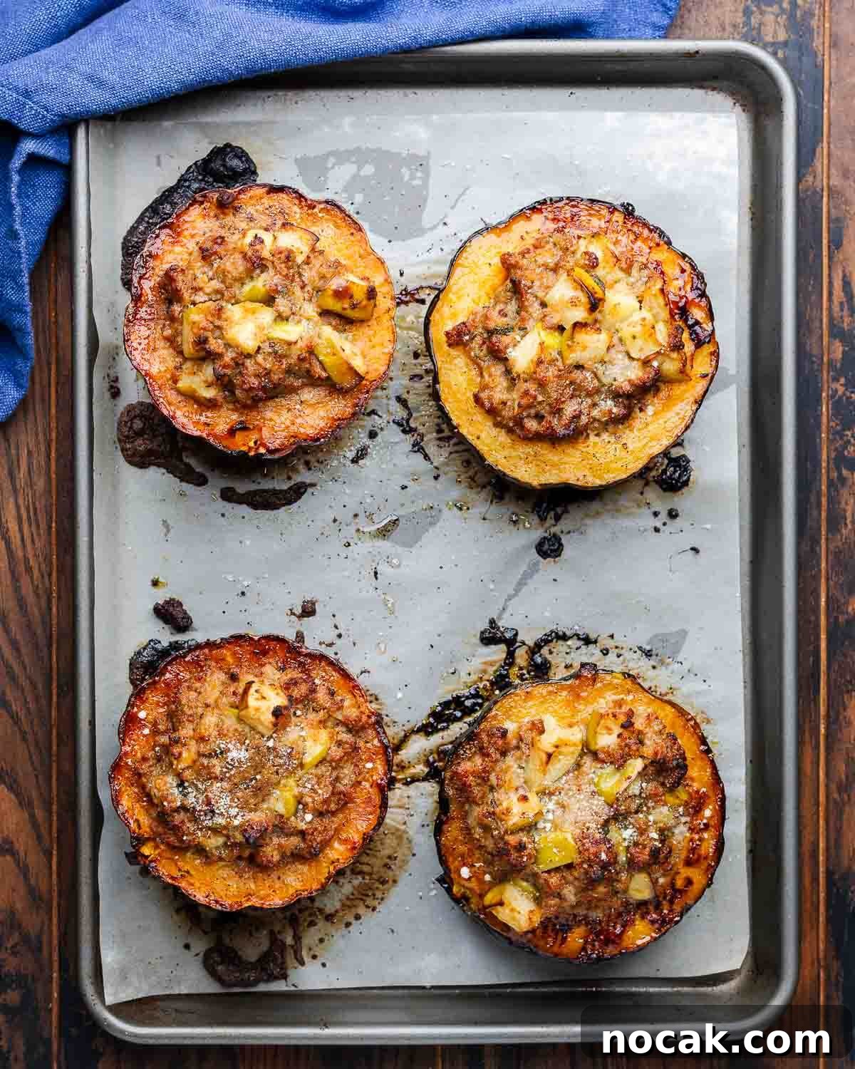 Sausage-Stuffed Acorn Squash Recipe for Cozy Fall Dinners 6 Overhead shot of baking sheet with 4 stuffed acorn squash halves.