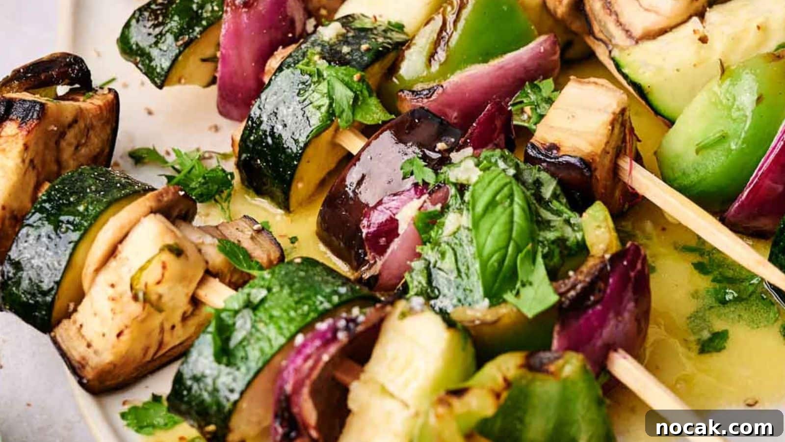 23 Crowd-Pleasing Cookout Recipes for Memorial Day Weekend 16 Close-up of grilled veggie kabobs with zucchini, bell peppers, eggplant, and onions, garnished with fresh herbs.