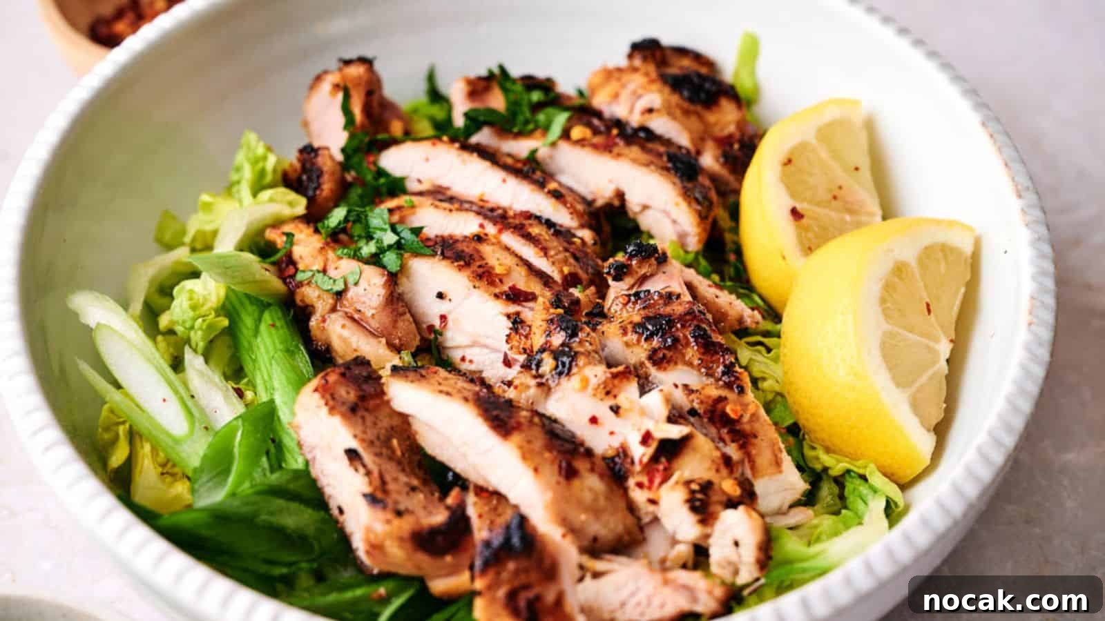 23 Crowd-Pleasing Cookout Recipes for Memorial Day Weekend 3 Grilled chicken breast slices served over a bed of greens with lemon wedges on the side.