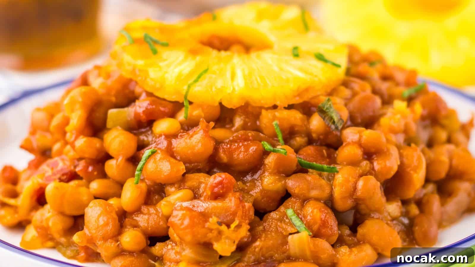 23 Crowd-Pleasing Cookout Recipes for Memorial Day Weekend 21 A plate of Hawaiian baked beans garnished with a pineapple slice and chopped herbs.