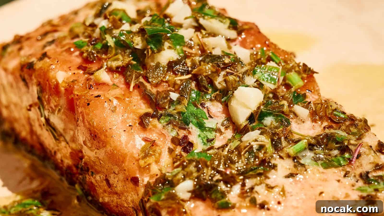 23 Crowd-Pleasing Cookout Recipes for Memorial Day Weekend 5 A close-up of a cooked salmon fillet topped with a mixture of chopped herbs, garlic, and seasonings.