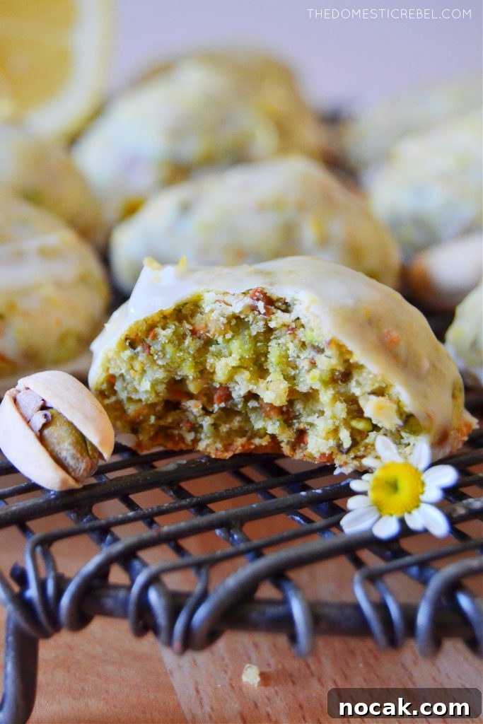 Pistachio Lemon Snowball Cookies Recipe for Zesty, Crunchy Treats 4 a bitten pistachio lemon cookie with a pistachio nut and a daisy