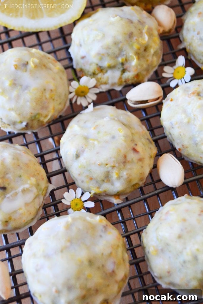 Pistachio Lemon Snowball Cookies Recipe for Zesty, Crunchy Treats 5 closeup of pistachio lemon cookies on a wire rack with pistachio nuts and daisies
