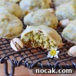 Pistachio Lemon Snowball Cookies Recipe for Zesty, Crunchy Treats 7 pistachio lemon snowball cookies on wire rack with pistachio nuts and daisies