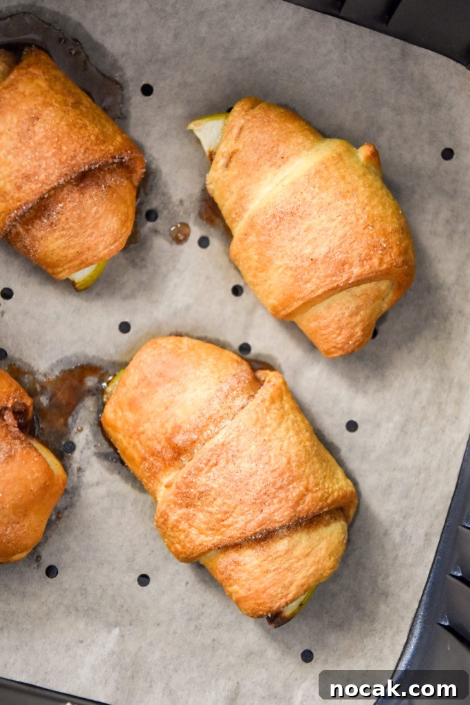 Air Fryer Apple Pie Crescent Rolls Recipe 16 close up of cooked apple pie crescent rolls in the air fryer.