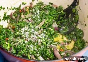 Saag Bhaji Recipe: Creamy Indian Spinach Curry with Spices 10 Salt being added to spinach and onions frying in a pot