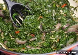 Saag Bhaji Recipe: Creamy Indian Spinach Curry with Spices 11 Sag Bhaji being stirred together with a spoon