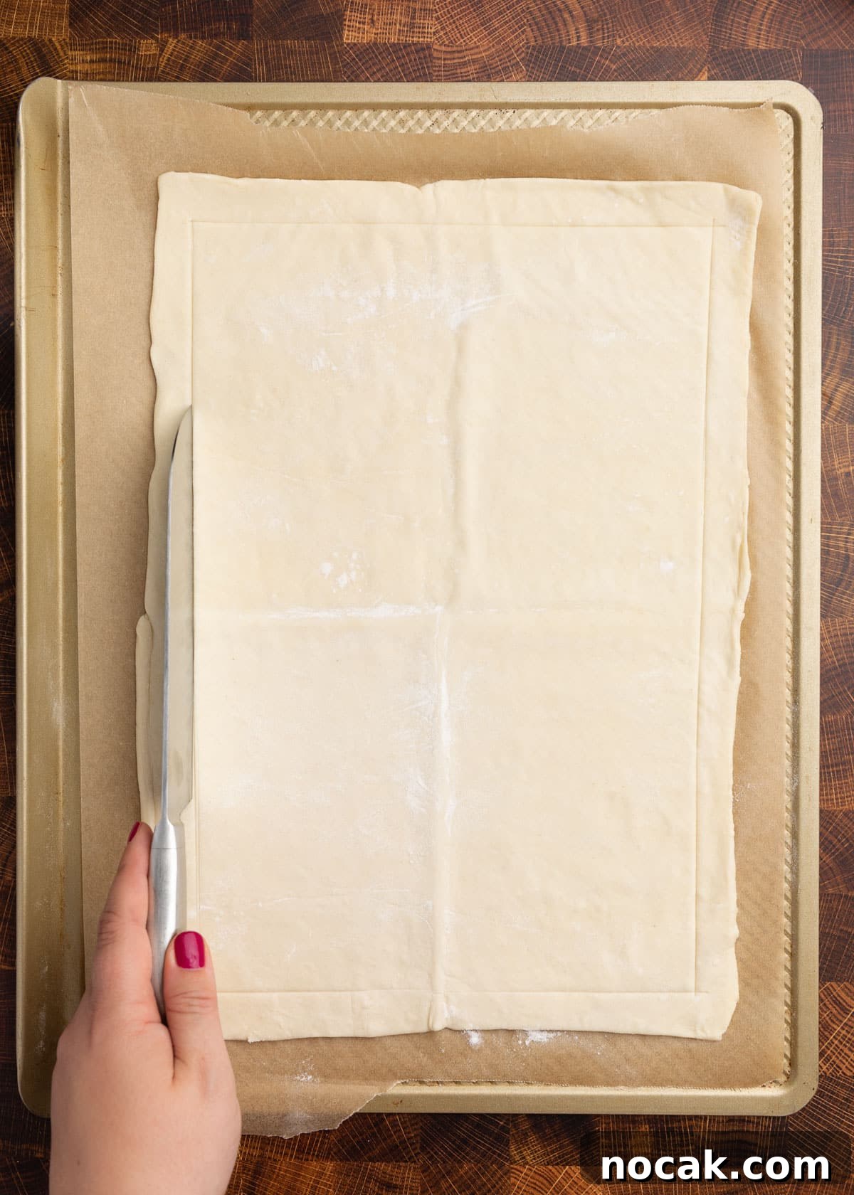 Crispy Puff Pastry Tomato Tart with Herbed Goat Cheese 5 overhead photo of puff pastry on a parchment lined baking sheet with a border being scored with a chef's knife