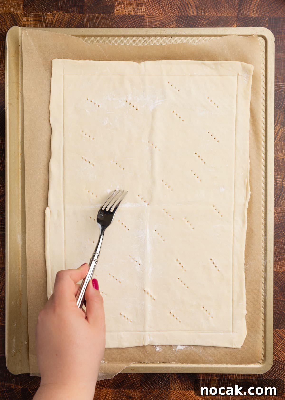 Crispy Puff Pastry Tomato Tart with Herbed Goat Cheese 6 overhead photo of puff pastry on a parchment lined baking sheet being docked with a fork