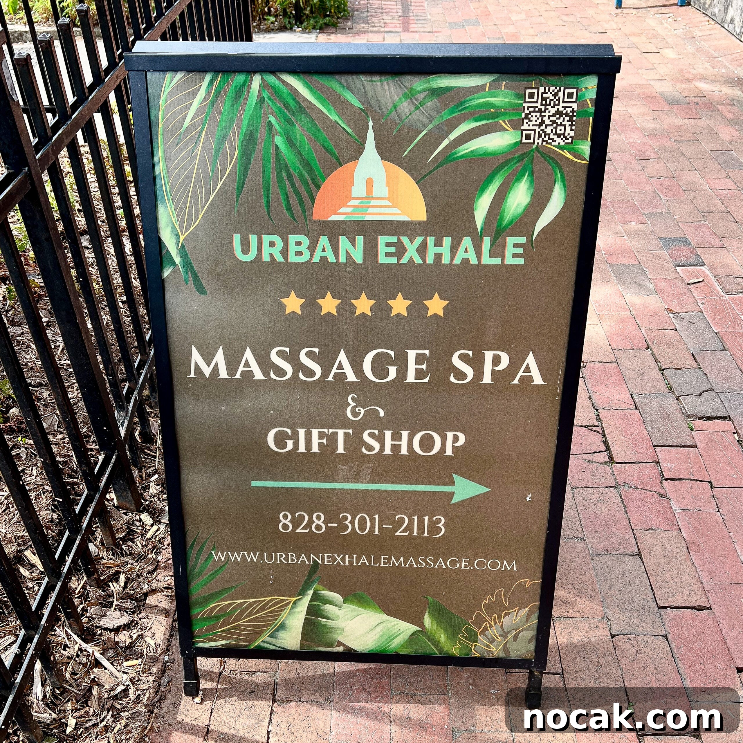 A romantic sidewalk sign reads Urban Exhale Massage Spa & Gift Shop.