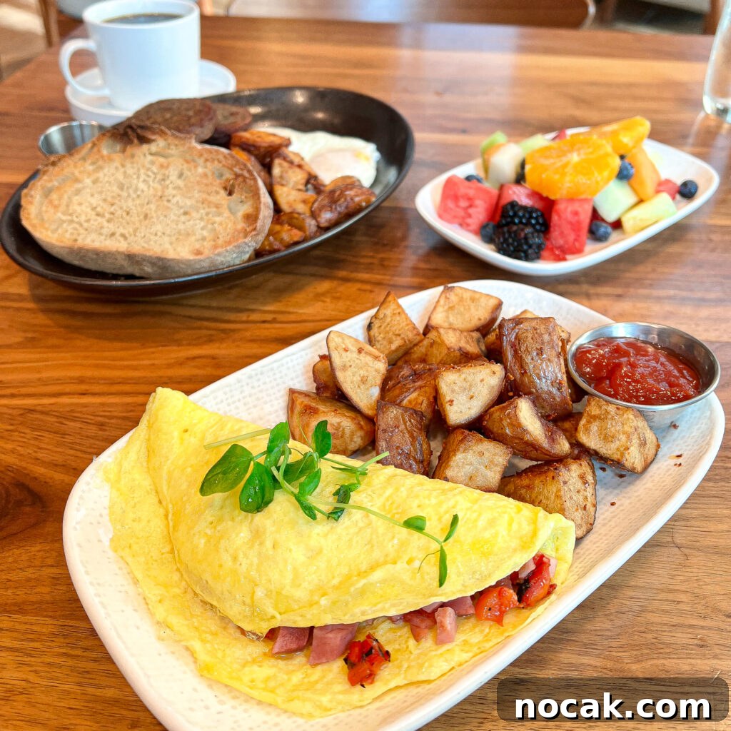 A cozy breakfast spread with omelet, roasted potatoes, fruit, toast, and coffee.