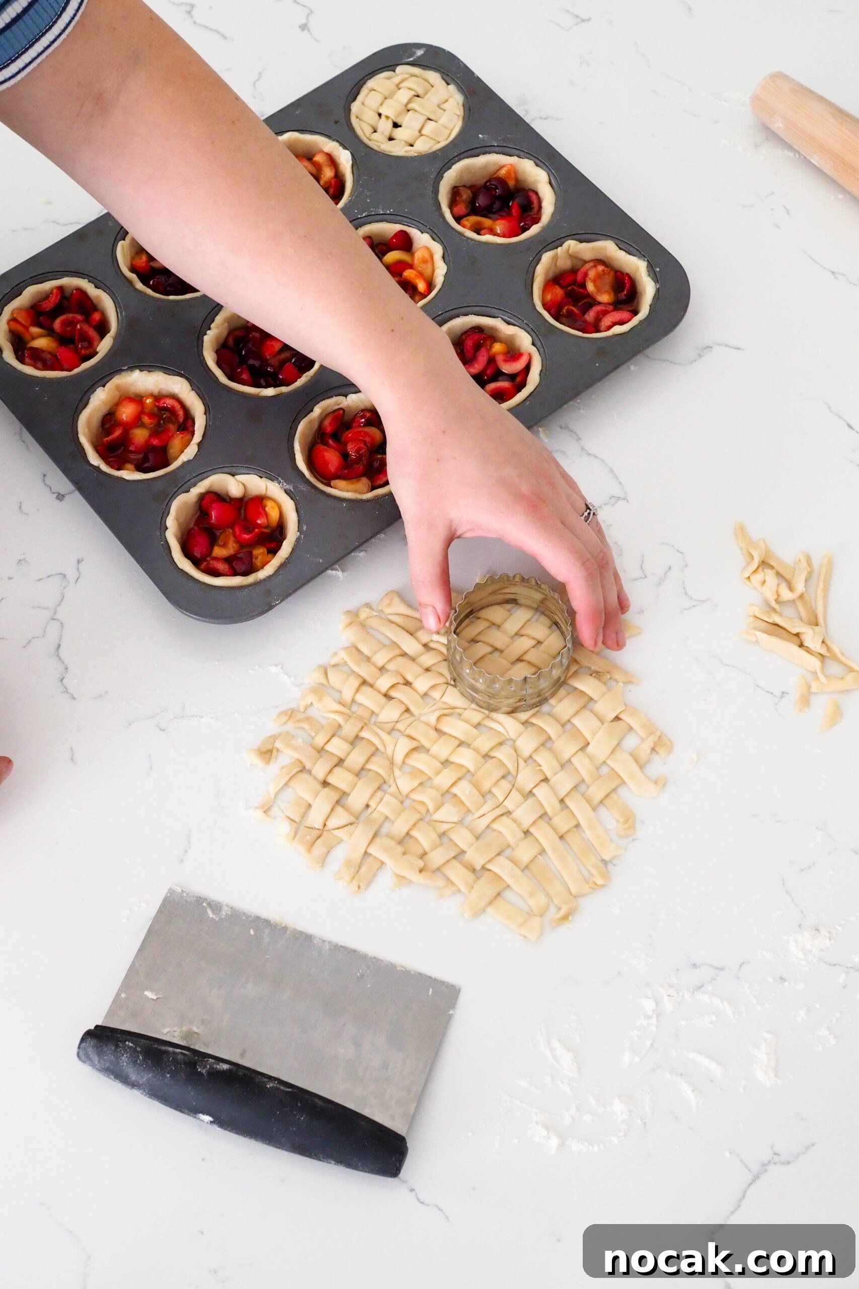 Mini Cherry Pies Recipe: Perfect Bite-Sized Cherry Hand Pies 10 A hand uses a round cutter to cut out a small lattice.