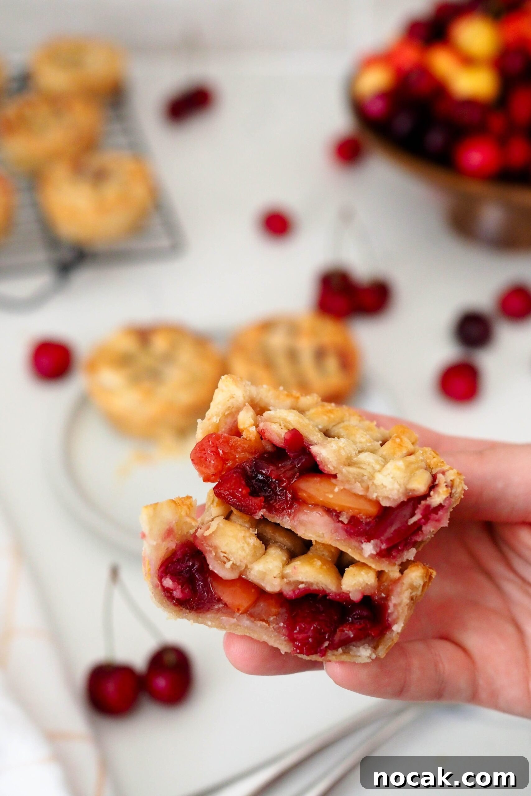 Mini Cherry Pies Recipe: Perfect Bite-Sized Cherry Hand Pies 14 A hand holds up two halves of a mini cherry pie.