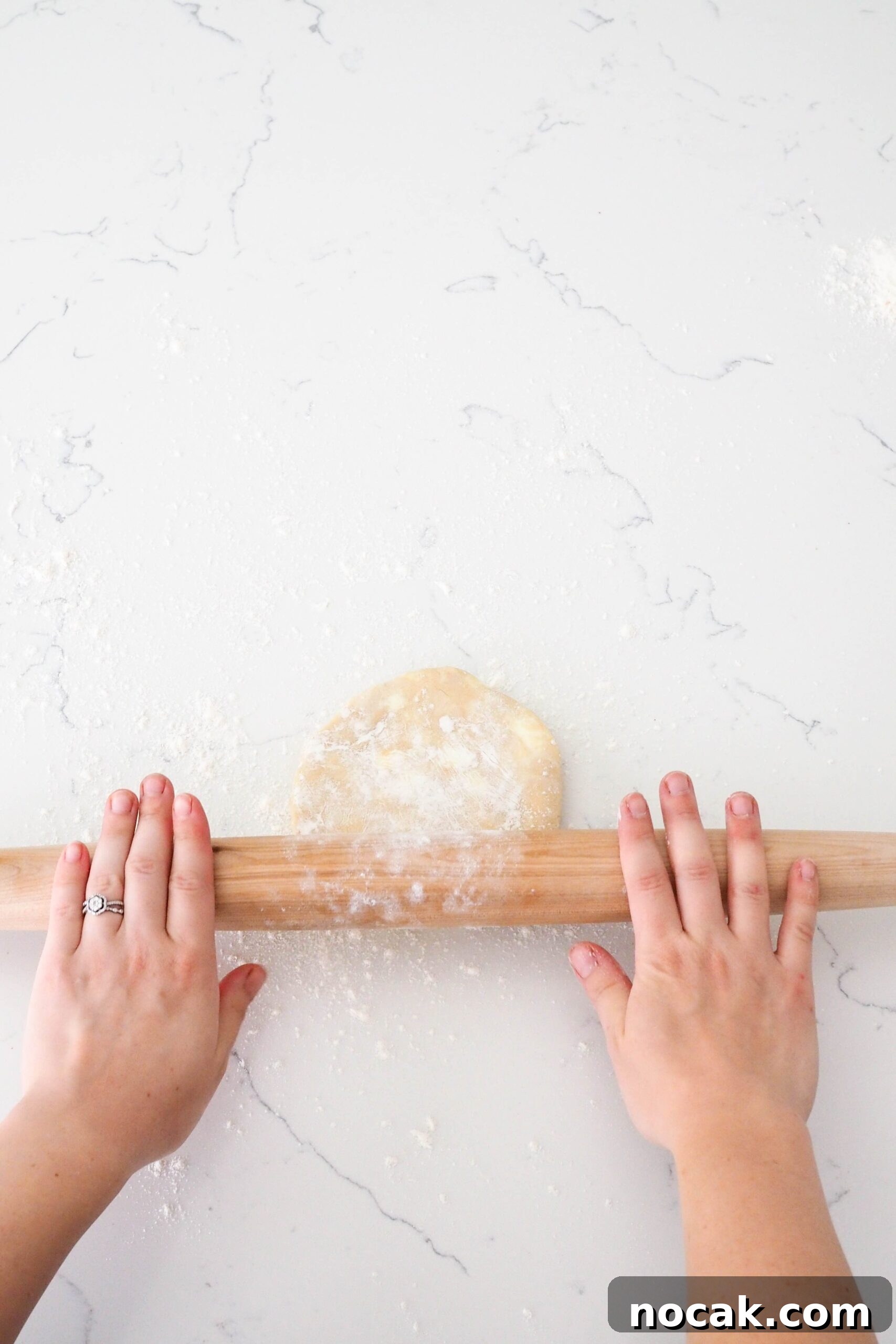 Mini Cherry Pies Recipe: Perfect Bite-Sized Cherry Hand Pies 6 Two hands push a rolling pin over a pie crust.