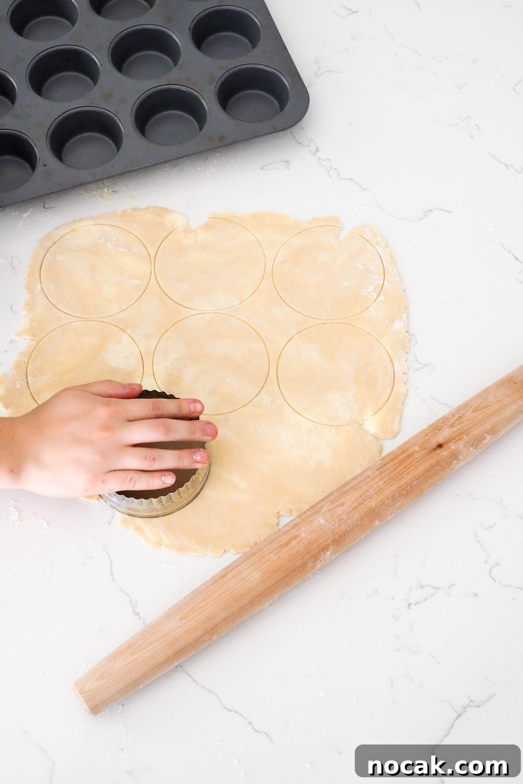Mini Cherry Pies Recipe: Perfect Bite-Sized Cherry Hand Pies 7 A hand cuts circles out of a rolled out pie crust.