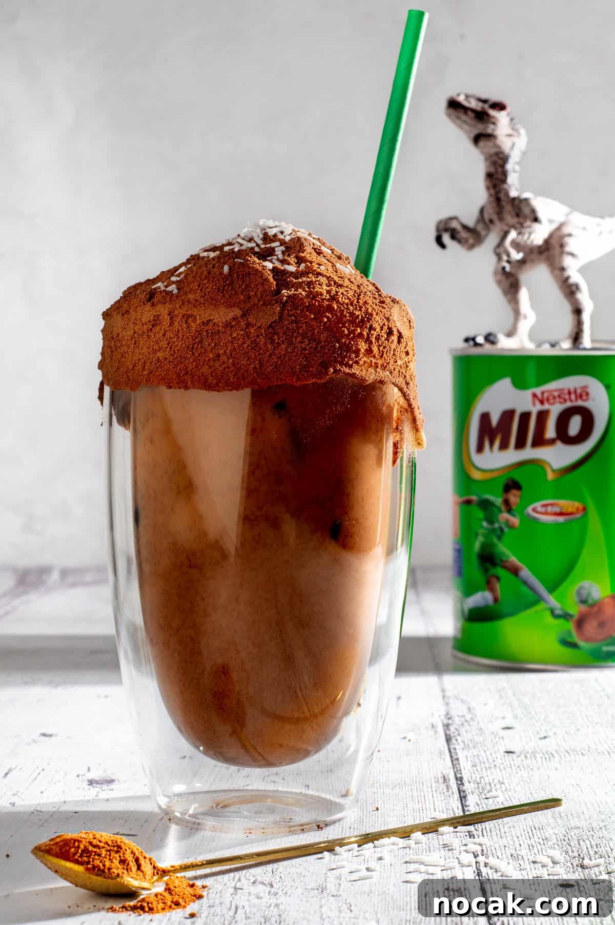 Iced Milo Dinosaur with Condensed Milk: Creamy Milo Drink Recipe 2 Milo dinosaur next to a tin of Milo and a plastic dinosaur.