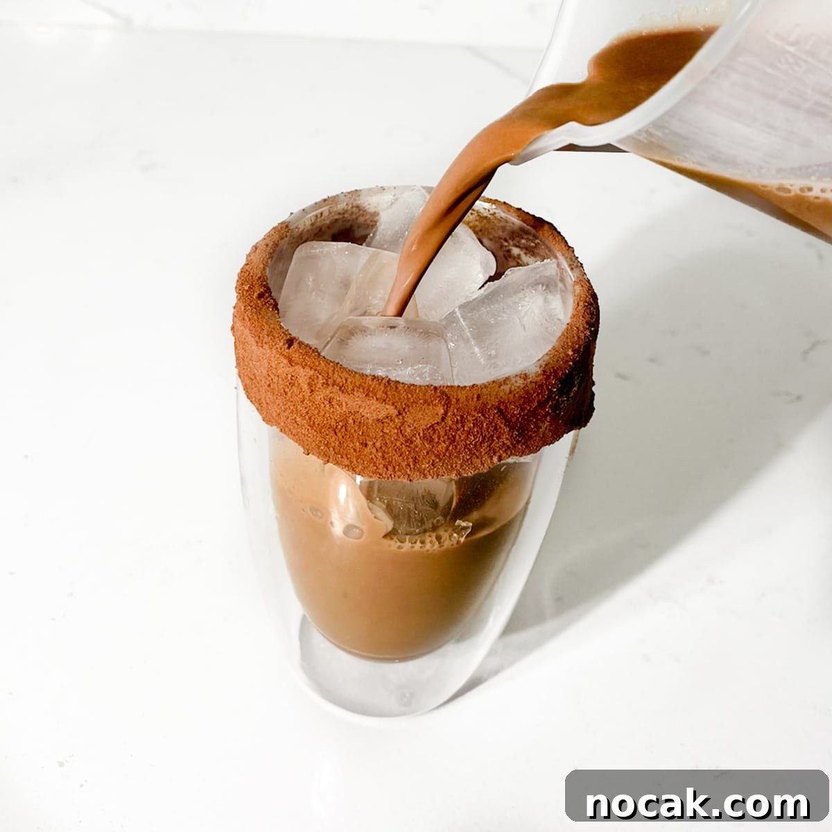 Iced Milo Dinosaur with Condensed Milk: Creamy Milo Drink Recipe 12 Pouring the milo dinosaur into the glass with ice.