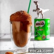 Iced Milo Dinosaur with Condensed Milk: Creamy Milo Drink Recipe 13 Milo dinosaur next to a tin of Milo and a plastic dinosaur.