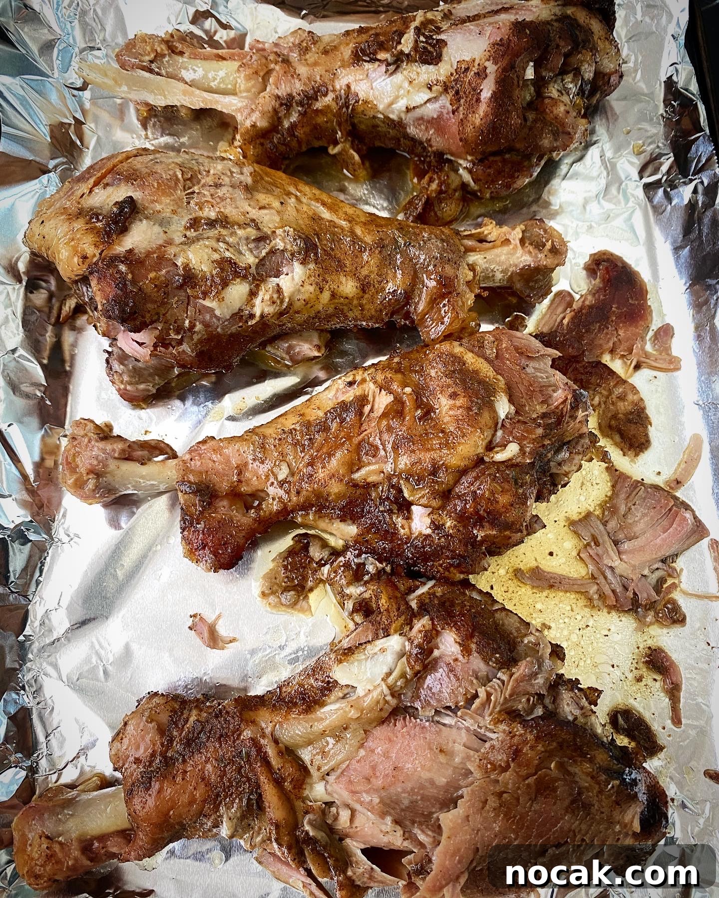 Slow Cooker Turkey Legs Recipe with Step-by-Step Video 6 overhead shot of cooked turkey legs on a foil lined baking sheet