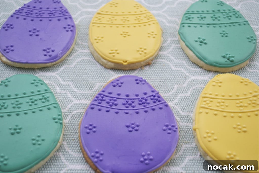 Gluten-Free Easter Sugar Cookies: Soft, Festive Egg Cookies 4 Sugar cookies decorated with purple, yellow and green royal icing to look like Eggs with raised dot designs.
