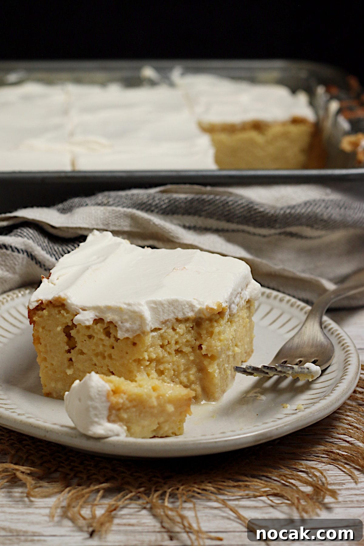 Gluten-Free Corn Tres Leches Cake Recipe for Moist, Flavorful Dessert 4 A slice of gluten-free Corn Tres Leches Cake on a small white plate.