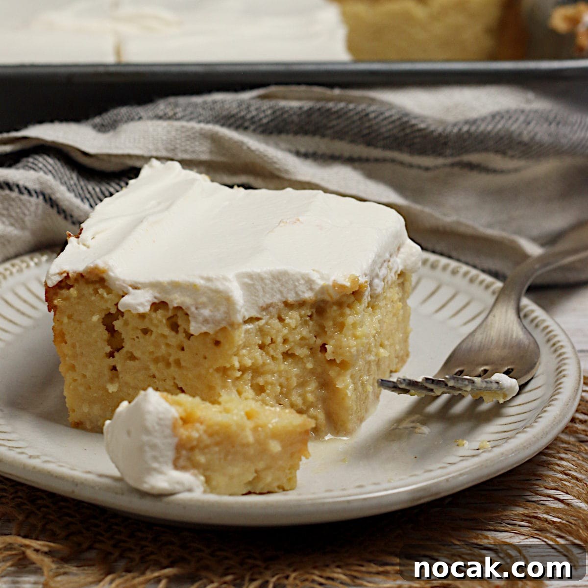 Gluten-Free Corn Tres Leches Cake Recipe for Moist, Flavorful Dessert 9 A slice of gluten-free Corn Tres Leches Cake on a small white plate.
