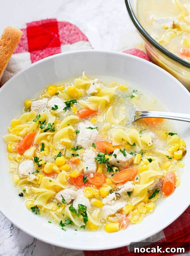 Comforting Chicken and Corn Noodle Soup Recipe 2 white bowl with chicken corn noodle soup and spoon