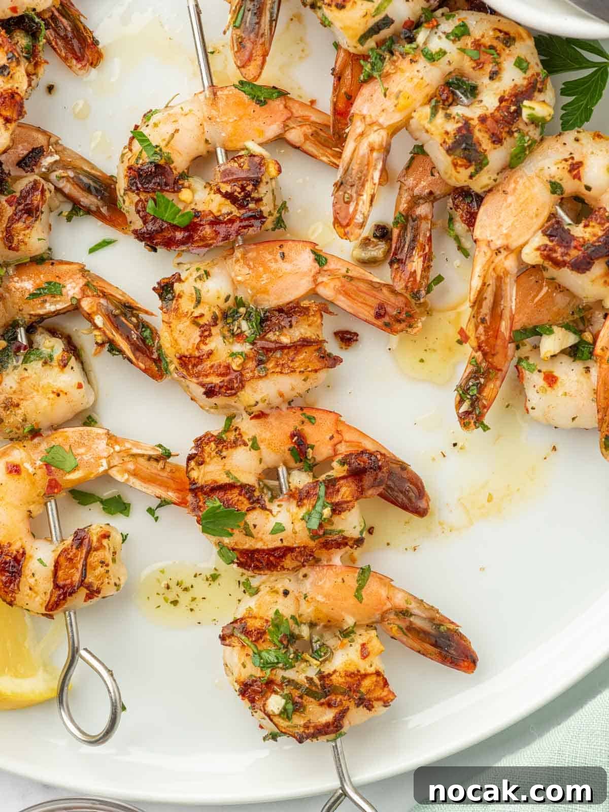 Garlic-Grilled Shrimp Skewers with Zesty Lemon Marinade 8 Garlicky shrimp skewers on a plate.