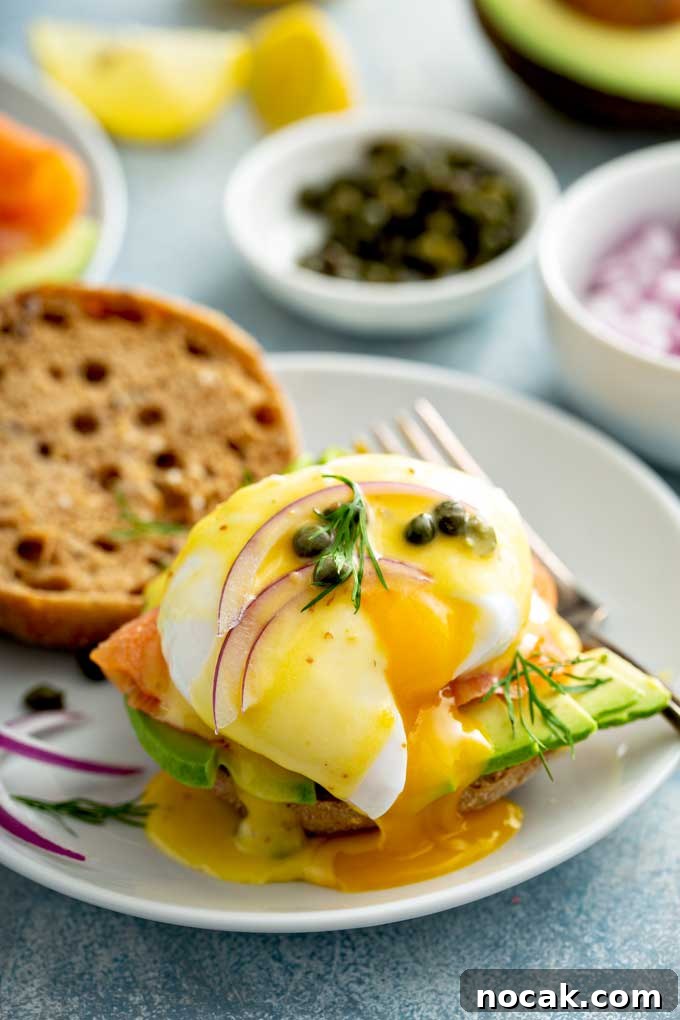 Poached egg with a runny yolk with smoked salmon, avocado and Hollandaise sauce on English muffin's toast.