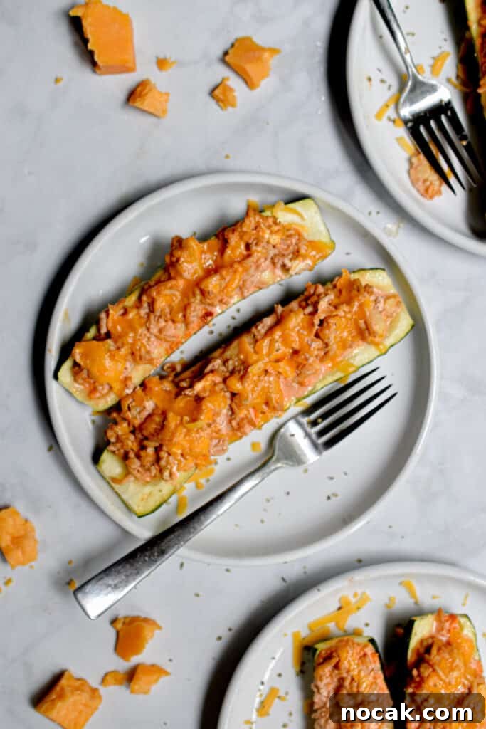 Buffalo Chicken Stuffed Zucchini Boats with Cheesy Filling 2 Two Buffalo Chicken Stuffed Zucchini are on a plate